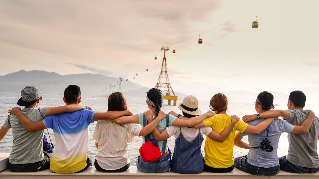 Photo by Duy Pham people holding shoulders sitting on wall